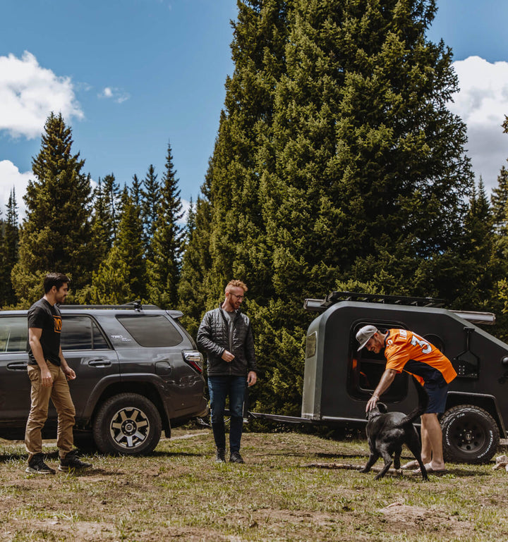 Men playing with dog while off-roading with Axle-less trailer 